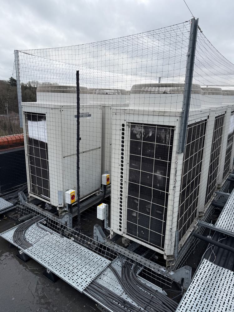 Rooftop air conditioning units enclosed in bird netting